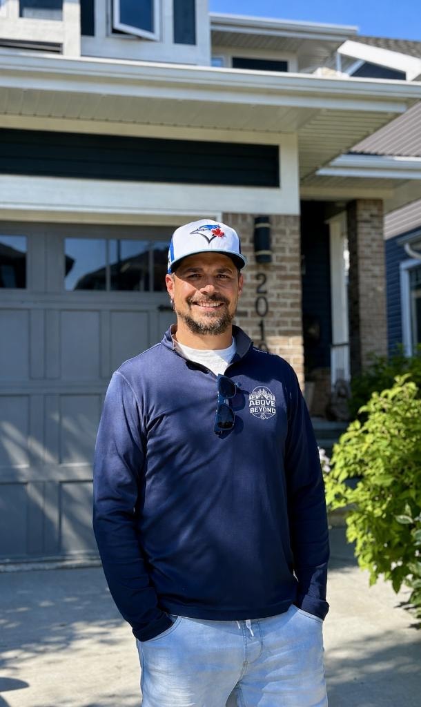 Darryl Henderson, certified home inspector, standing in front of a home